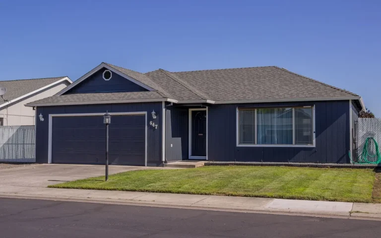 Single-story home with a blue garage door in Sterlington, LA